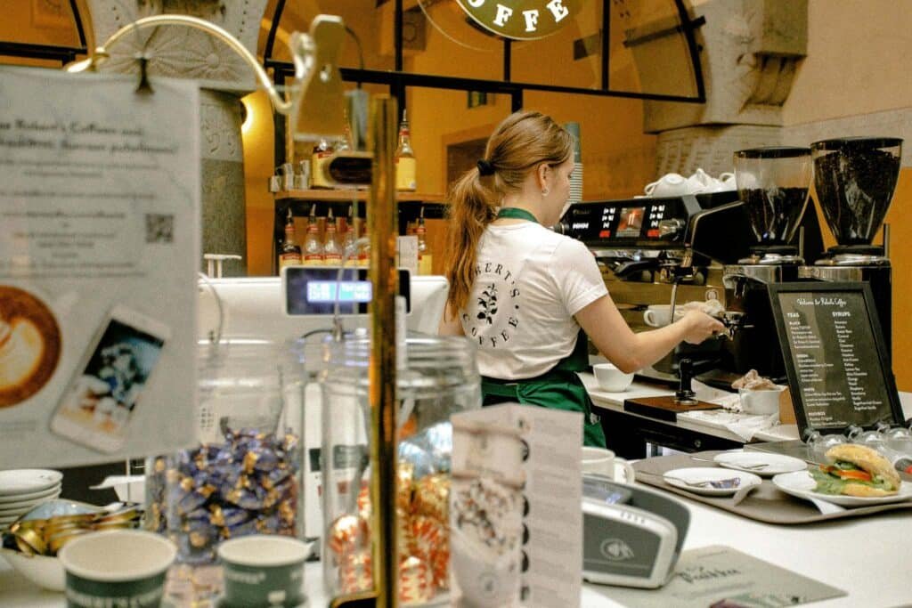 A student working in barista jobs part time in a UK coffee shop