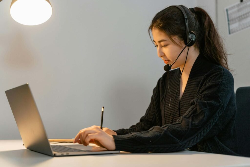 A person wearing headphones and typing for transcription work